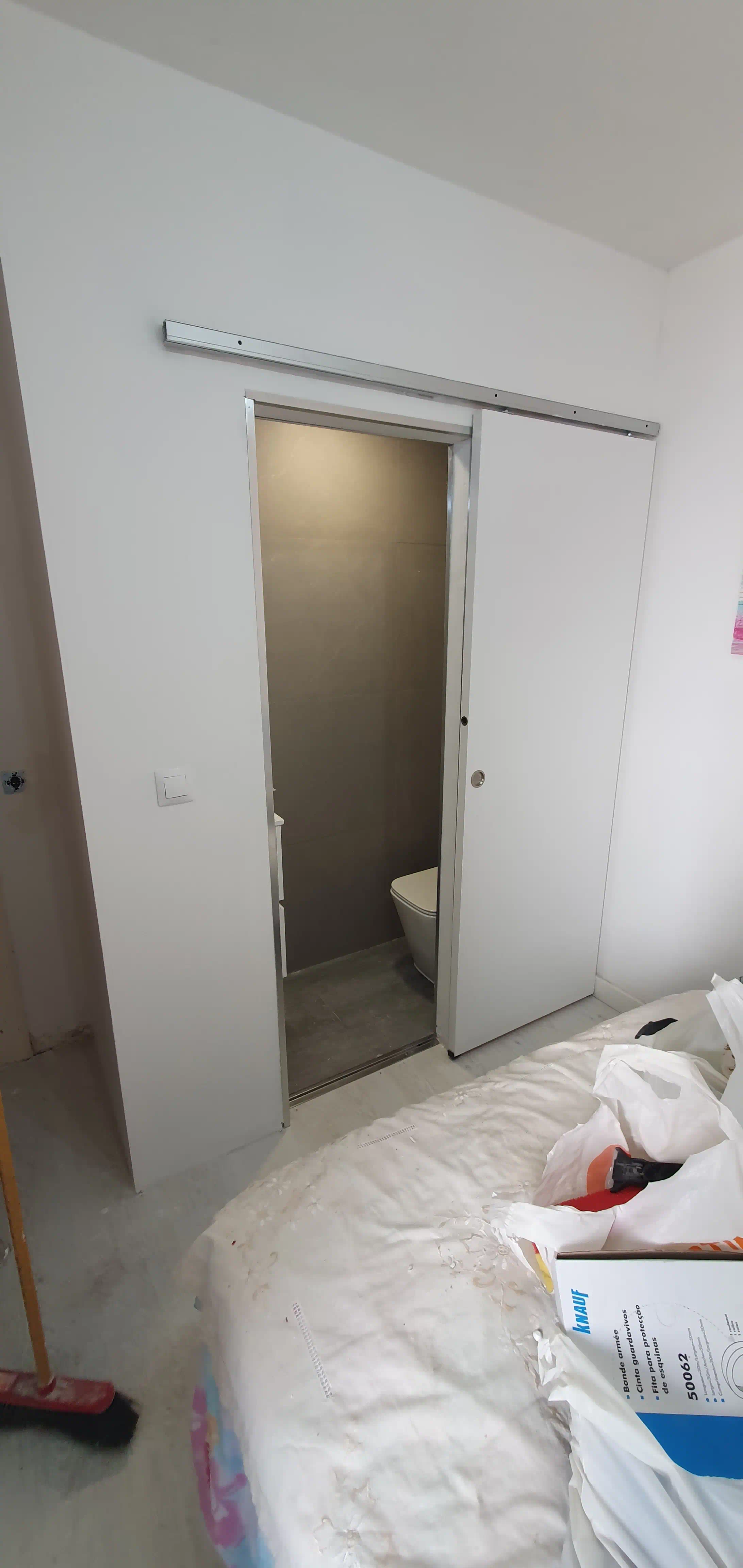 Aseo adaptado terminado con puerta corredera flotante en dormitorio